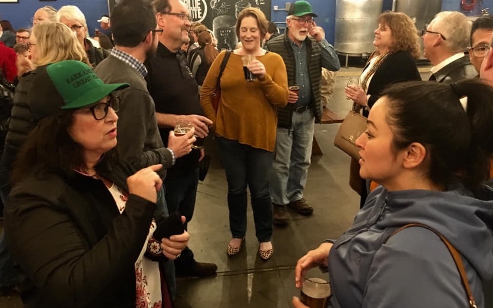 People talking inside Berryessa Brewing during a crowded civic gathering