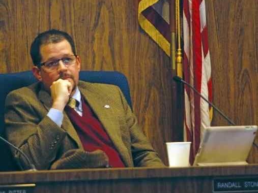 Councilmember seated at the Chico City Council dais with a laptop and meeting materials