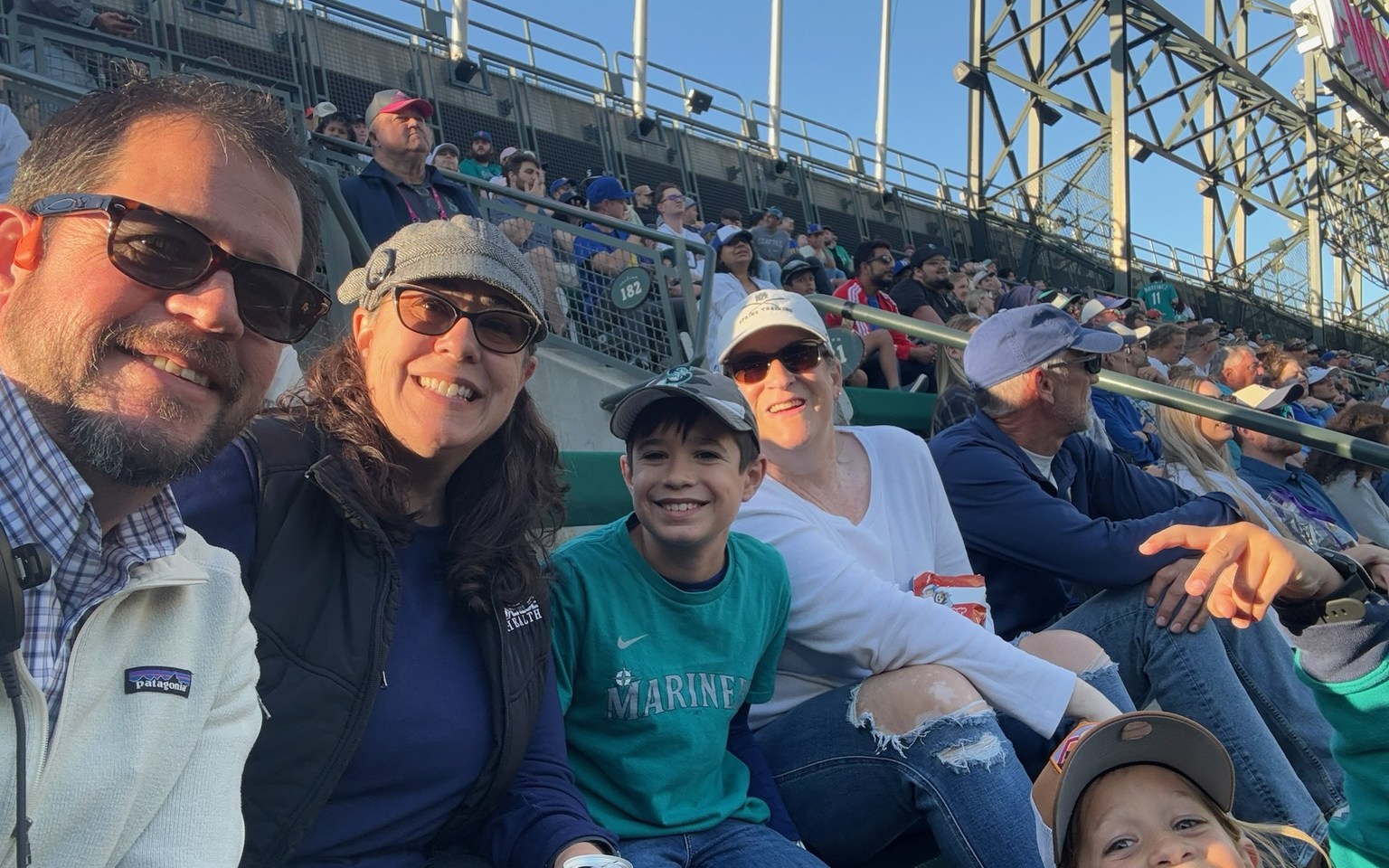 Family members together in stadium seating at a baseball game