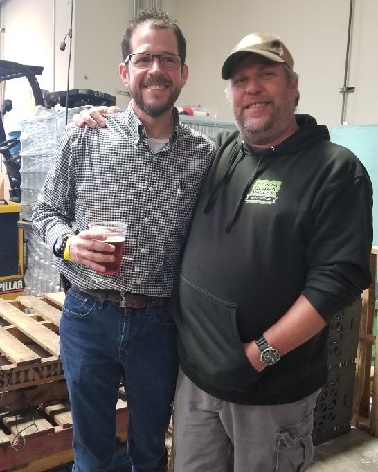 Two people standing together in a brewery production area