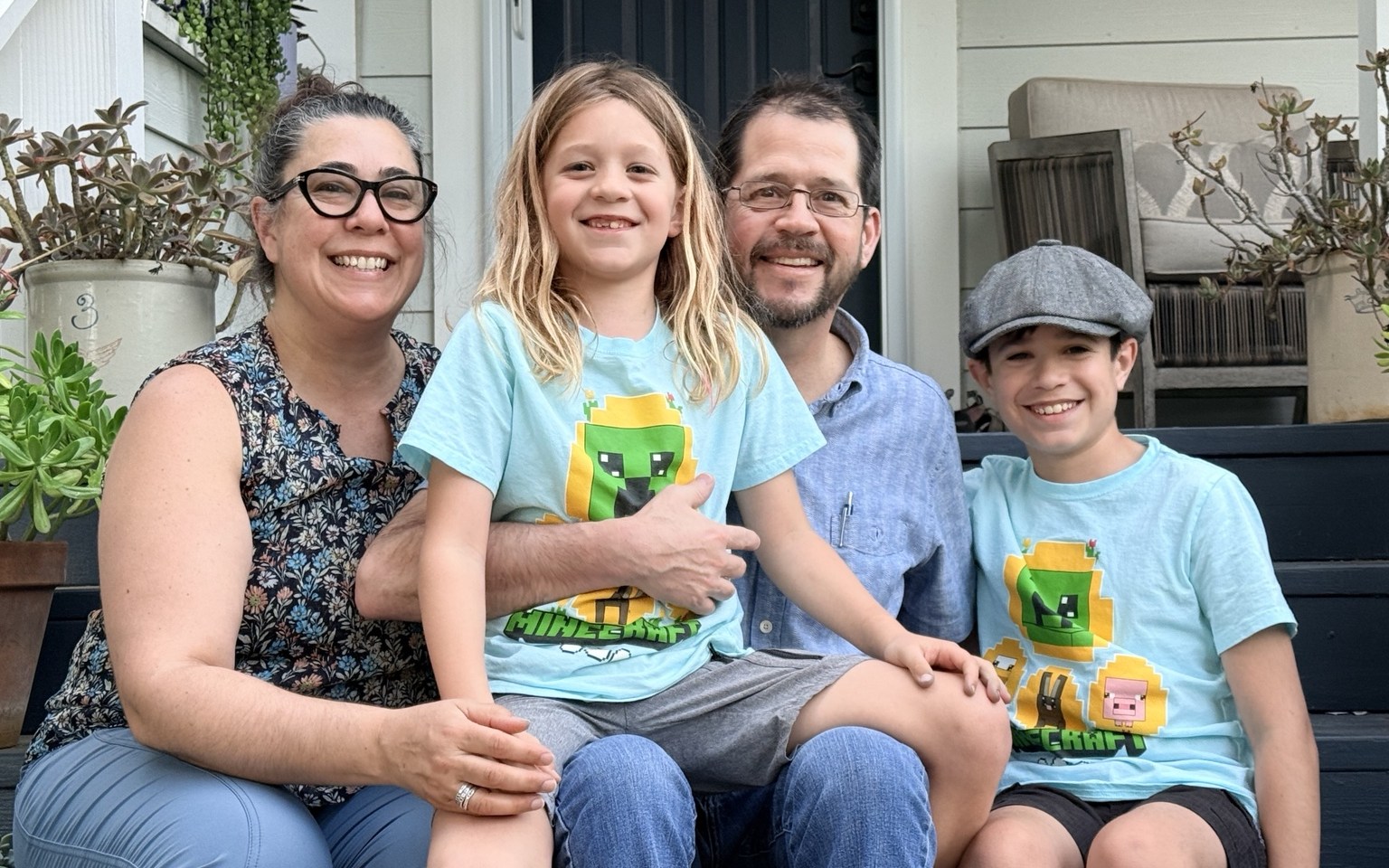 Stone family seated together on the front steps of a home