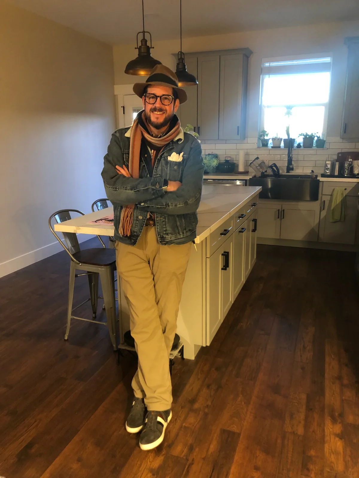 Randall Stone in a hat, scarf and denim jacket at home