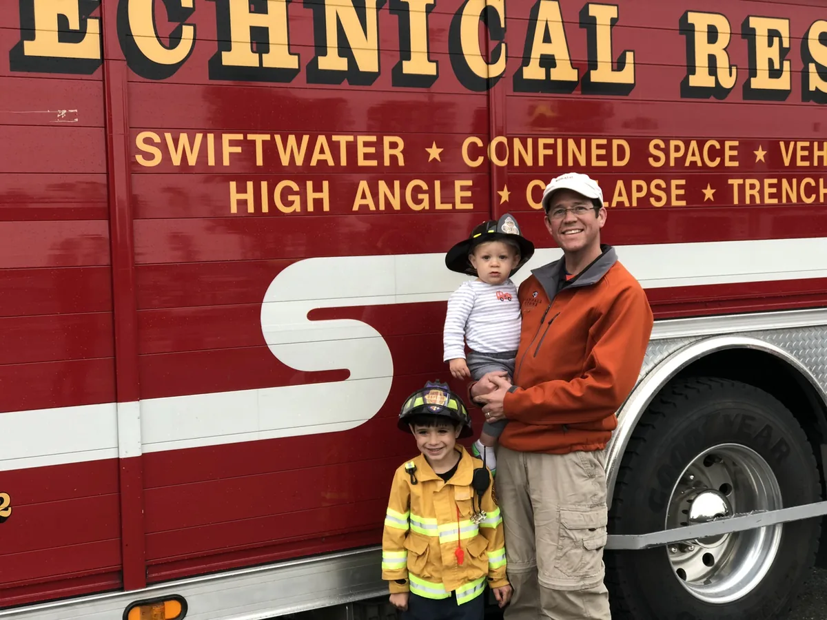 Randall Stone and two young family members beside technical-rescue fire apparatus