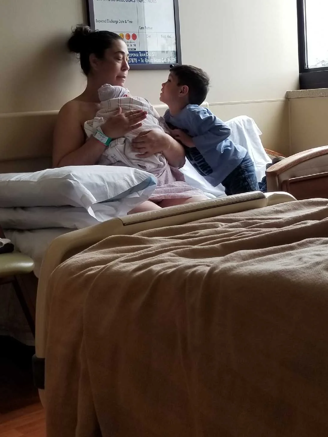 Krista Stone holding newborn Karden while Rhys visits in the hospital