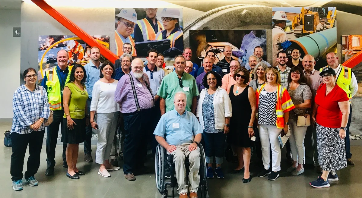 Participants at the PG&E Gas Safety Academy in Winters with a damaged San Bruno pipeline section displayed behind them