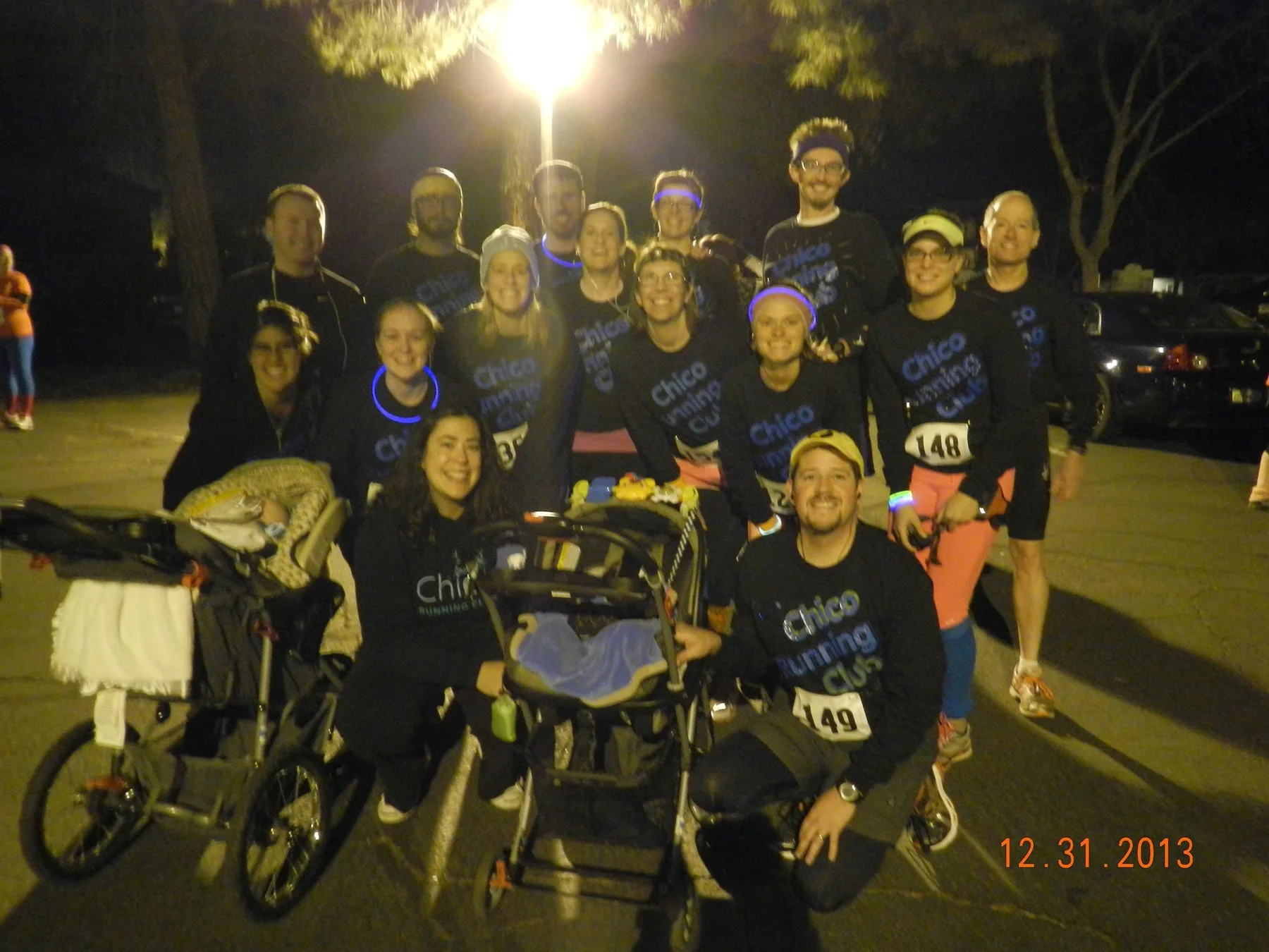 Chico Running Club members gathered at a nighttime event with running strollers