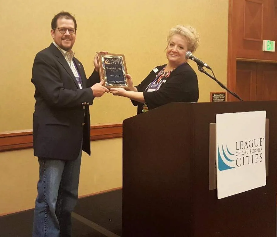 Randall Stone receiving a plaque from incoming Sacramento Valley Division President Melissa Hunt as he steps down as Division President