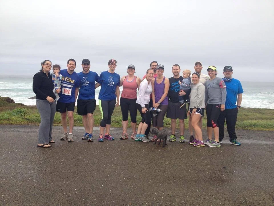 Chico Running Club friends gathered together at the coast, with Randall Stone holding young Rhys Stone