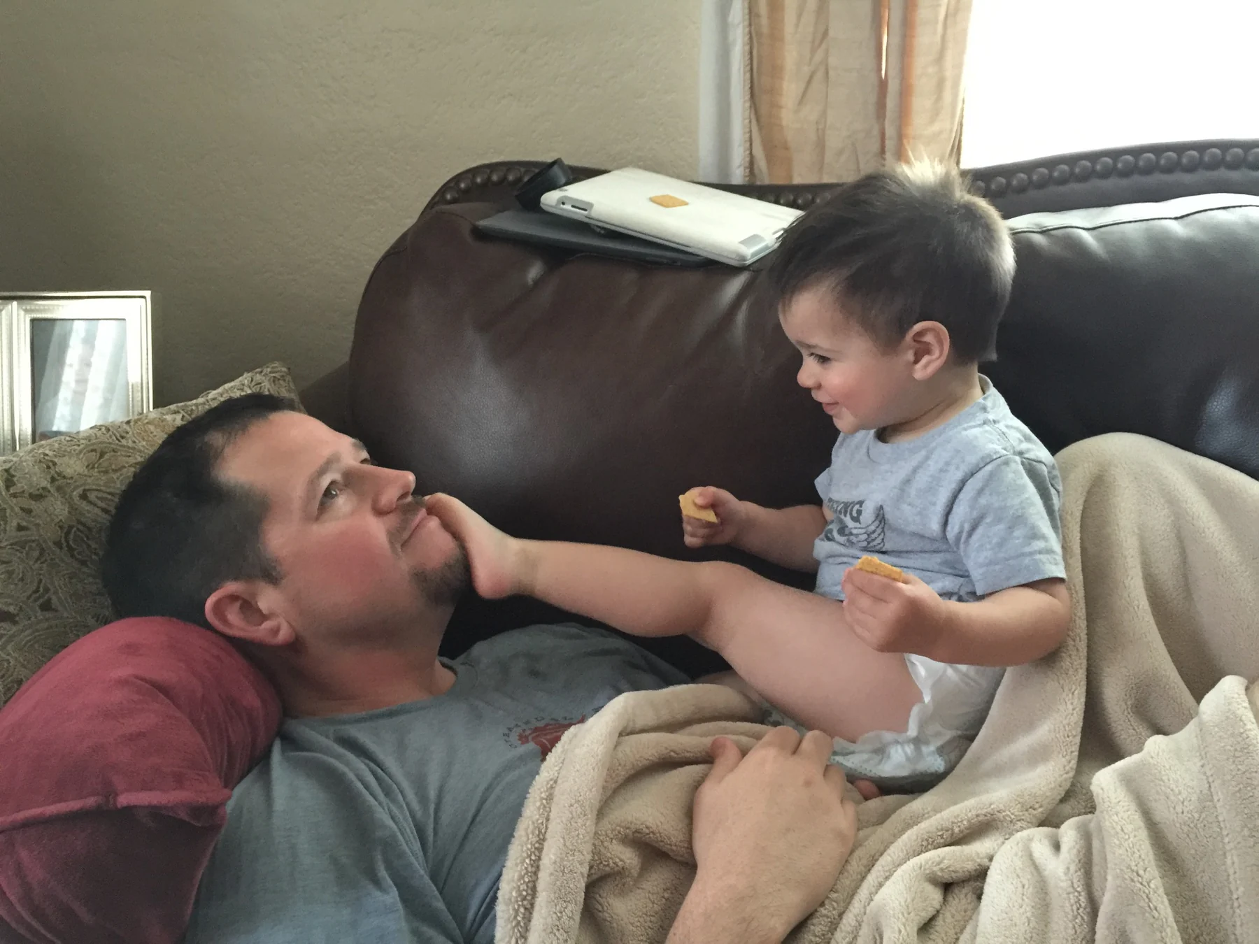 Randall Stone relaxing on a couch with toddler Rhys Stone