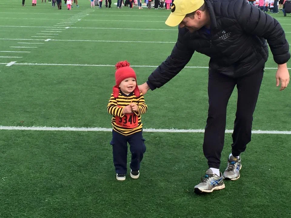 Randall Stone accompanying young Rhys Stone during a children’s running event