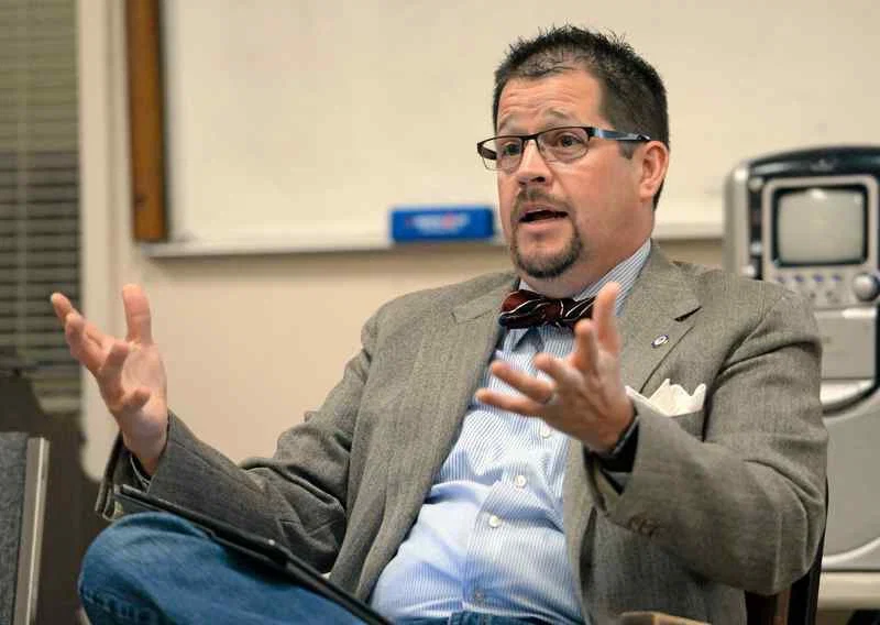 Randall Stone seated and speaking during a discussion