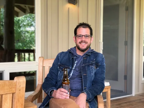 Randall Stone seated casually on a porch in 2019