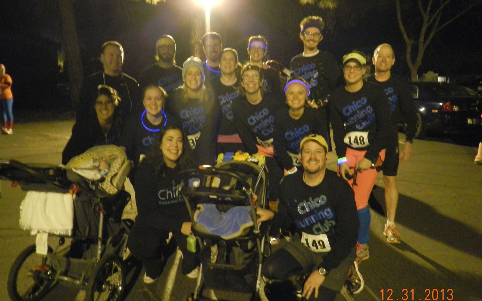 Chico Running Club members gathered after a nighttime event with running strollers