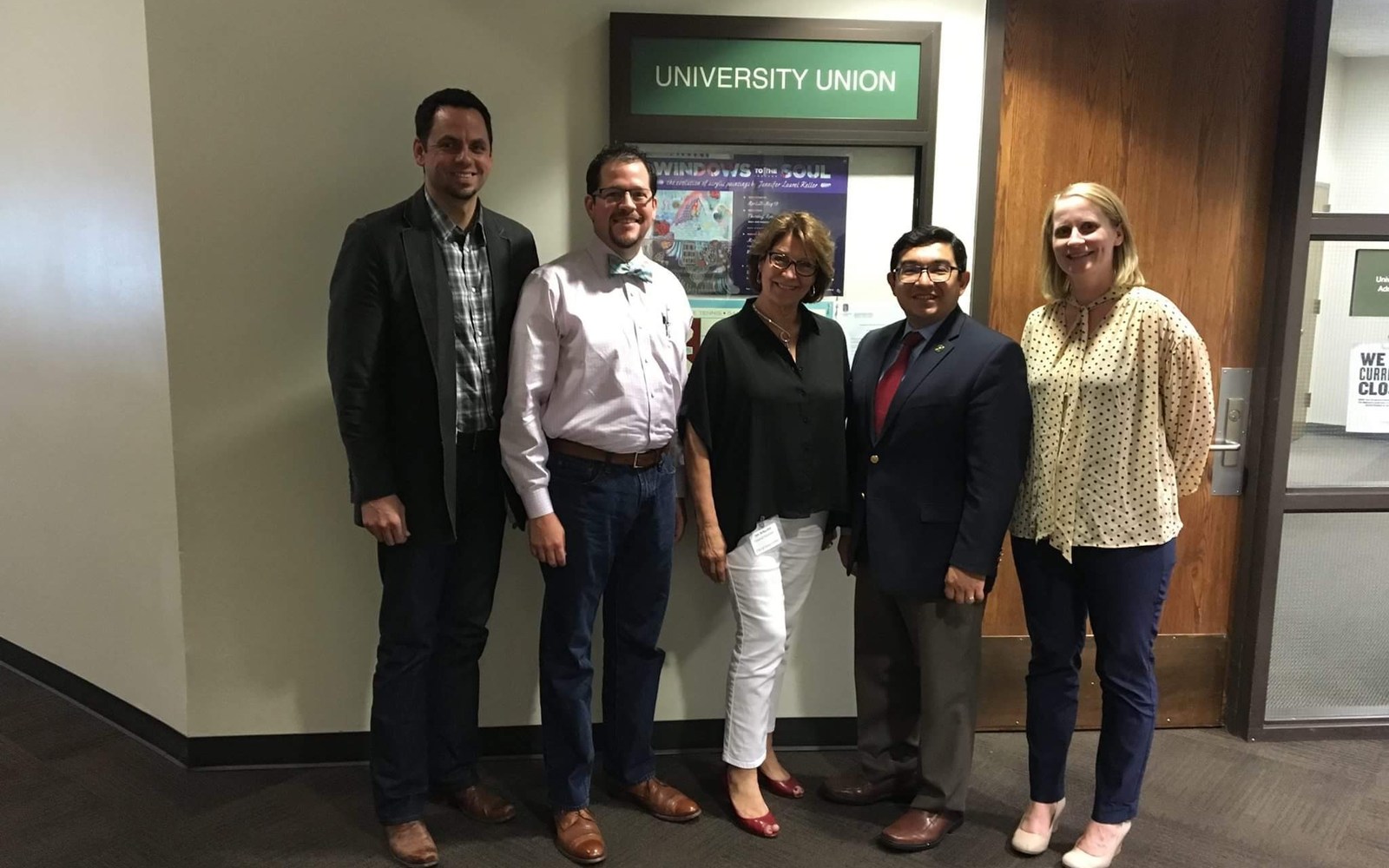Five people standing together outside a University Union office
