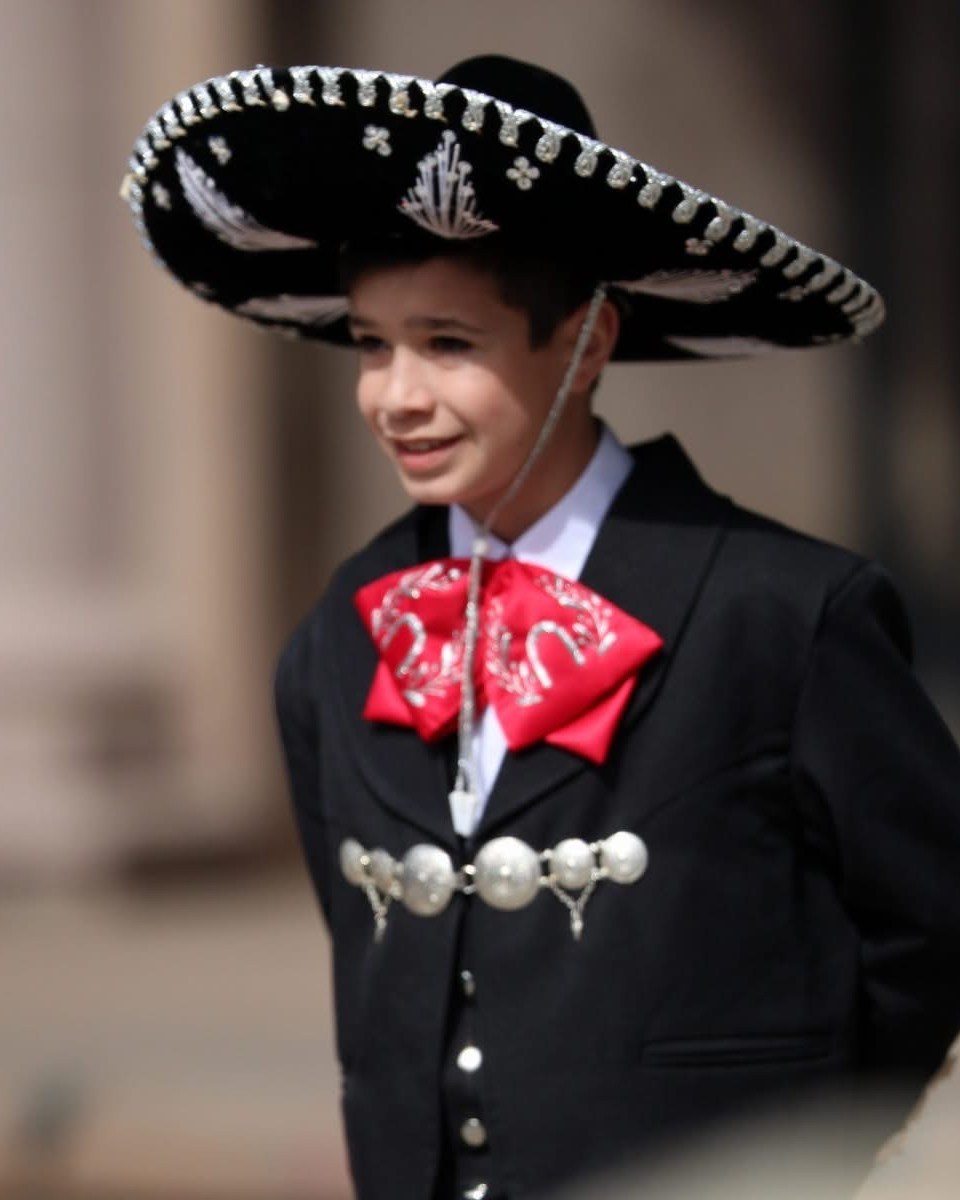 Young Ballet Folklórico performer in black charro attire and sombrero