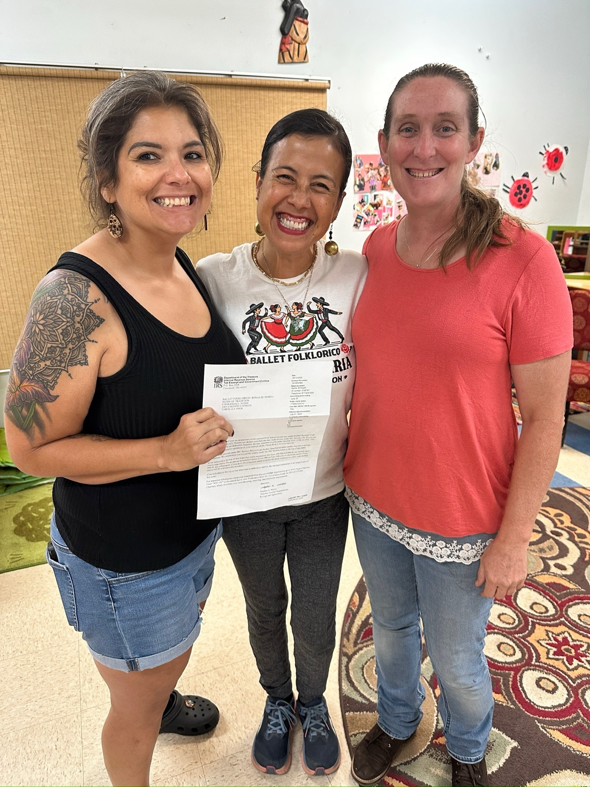 Latoyia Gonzalez, Maria Trenda y Joyce Becker con la carta de determinación del IRS de Rosas de María en la reunión de la Junta de mayo de 2025
